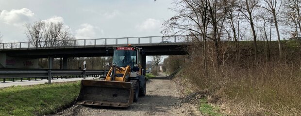 ein Radlader steht auf dem abgefrästen Asphalt ein Radlader steht auf dem abgefrästen Asphalt