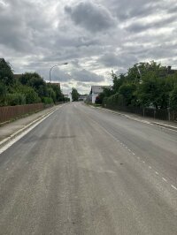 Fertiggestellte Asphaltdecke, mit Markierungsarbeiten